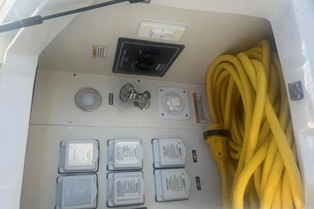 Slide: The Image of 2023 Sea Ray Sundancer 320 Outboard electrical panel with yellow power cable. - 45