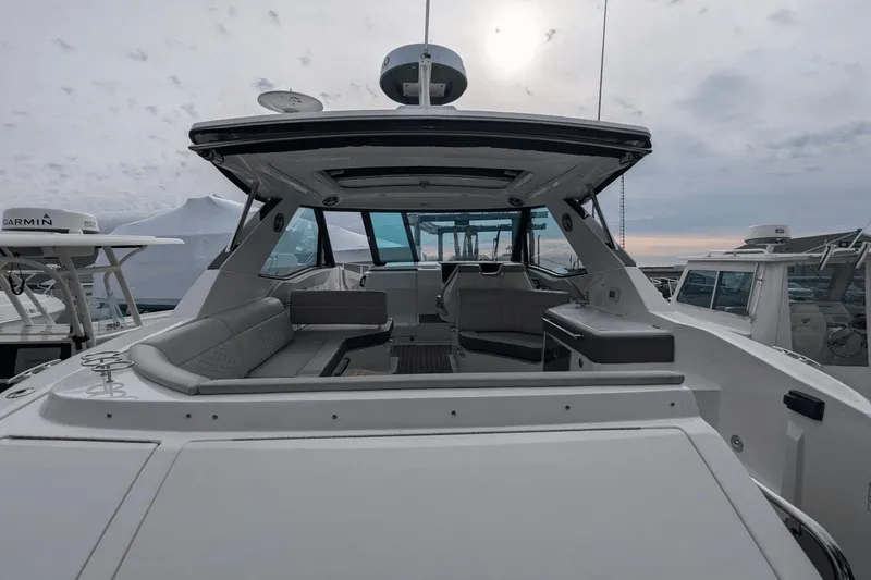 Slide: The Image of 2023 Sea Ray Sundancer 320 Outboard, spacious deck view, modern design, overcast sky. - 7