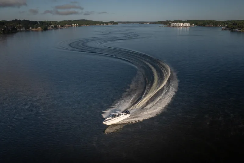 Slide: The Image of Fountain 39 DX boat making a sharp turn on a calm lake, 2026 model. - 10