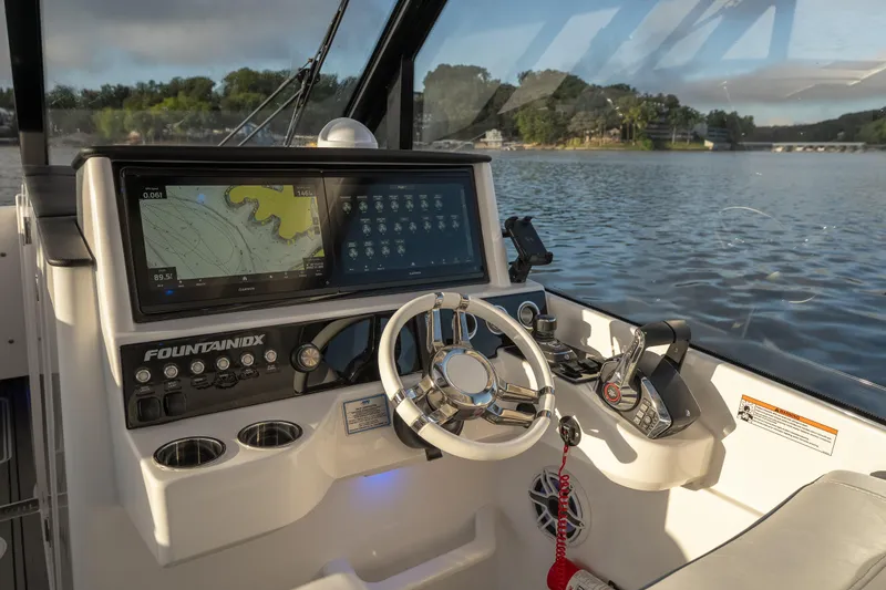 Slide: The Image of 2026 Fountain 39 DX boat cockpit with advanced navigation system on a serene lake. - 29