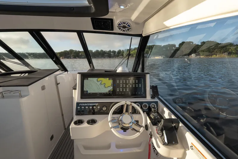 Slide: The Image of Helm of 2026 Fountain 39 DX boat with navigation display, steering wheel, and water view. - 30