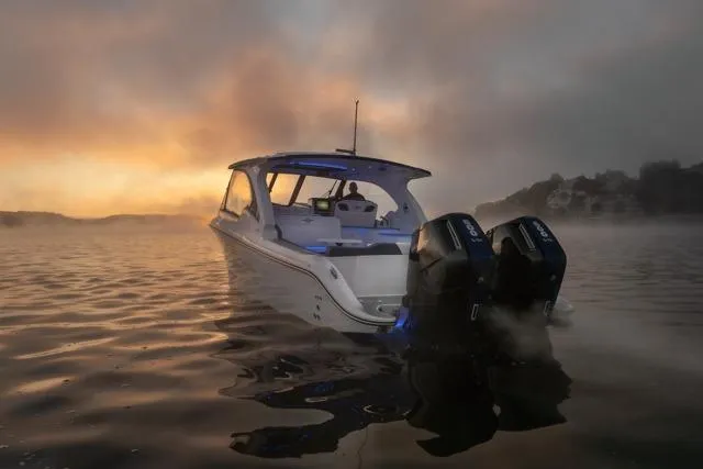 Slide: The Image of 2026 Fountain 39 DX boat on misty water at sunrise, featuring dual engines. - 6