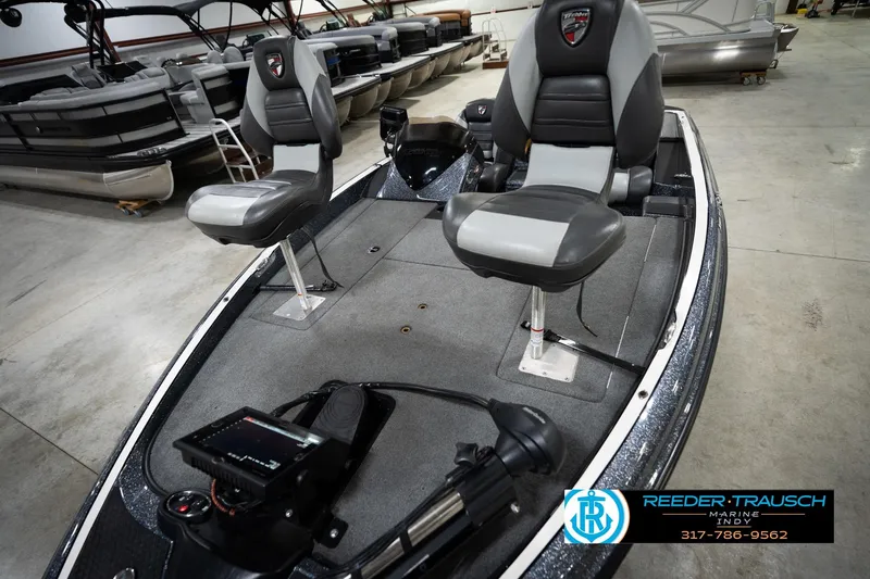 Slide: The Image of 2015 Triton 18TRX boat interior with dual seats and control panel in showroom. - 10