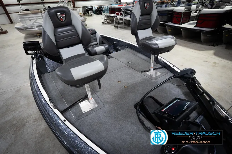 Slide: The Image of 2015 Triton 18TRX boat interior with dual seats and control panel in showroom. - 11