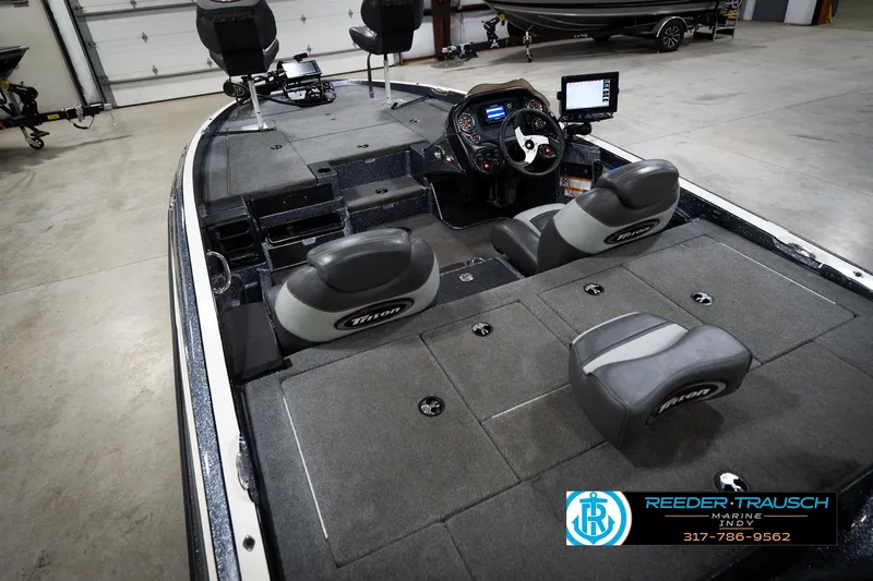 Slide: The Image of 2015 Triton 18TRX boat interior with steering console and seating in a showroom. - 13