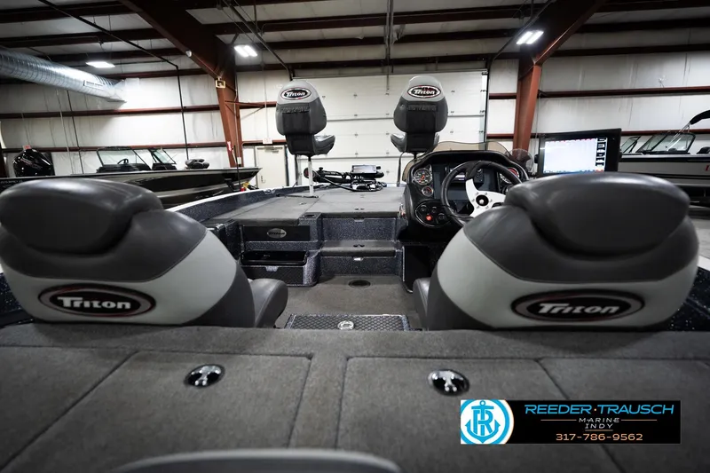 Slide: The Image of 2015 Triton 18TRX boat interior with seating and control panel in a showroom. - 14
