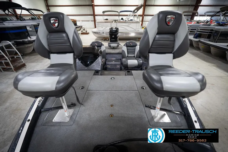 Slide: The Image of 2015 Triton 18TRX boat interior with two gray seats in a showroom. - 16