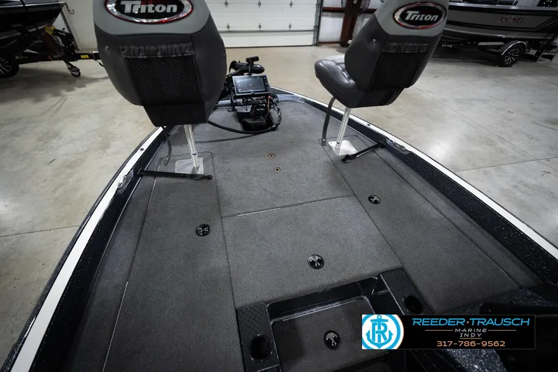 Slide: The Image of 2015 Triton 18TRX boat interior with seating and control panel in a showroom. - 21