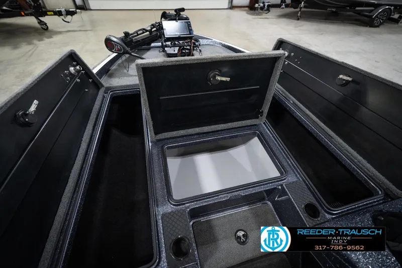 Slide: The Image of 2015 Triton 18TRX boat interior with open storage compartments and fishing equipment. - 23