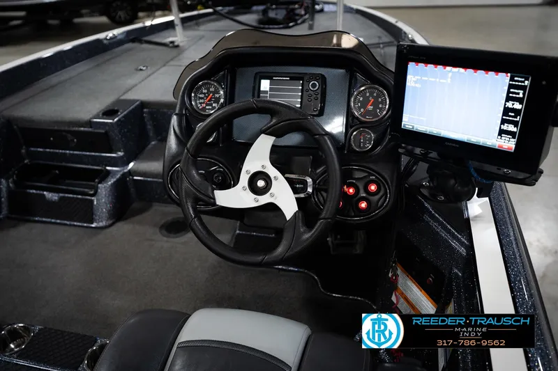 Slide: The Image of 2015 Triton 18TRX boat dashboard with steering wheel, gauges, and electronic display. - 24