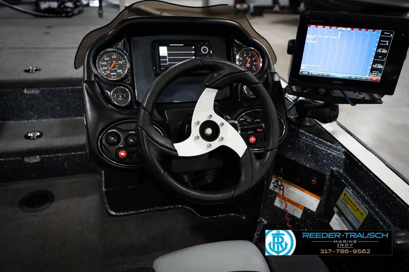Slide: The Image of 2015 Triton 18TRX boat dashboard with steering wheel and Garmin display. - 25