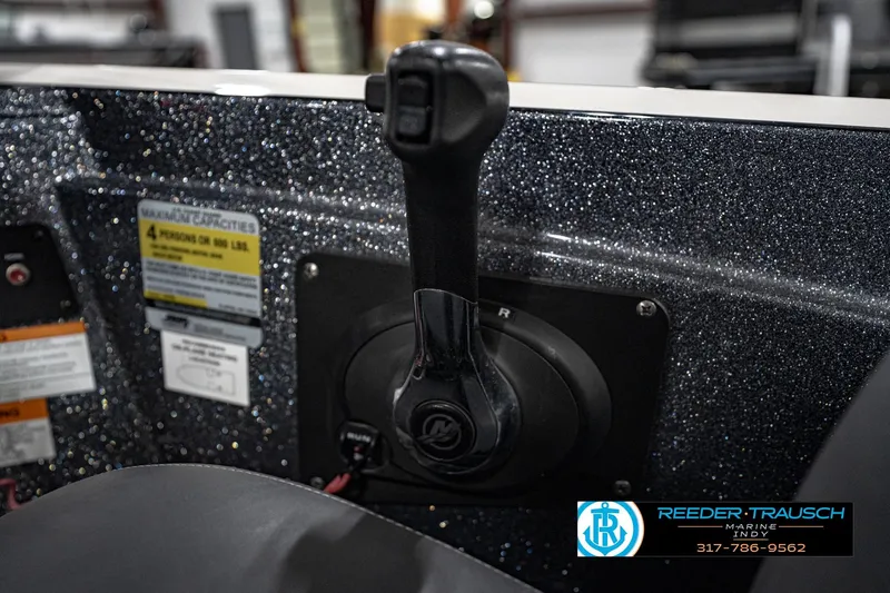 Slide: The Image of 2015 Triton 18TRX boat control panel with throttle lever and capacity label. - 37