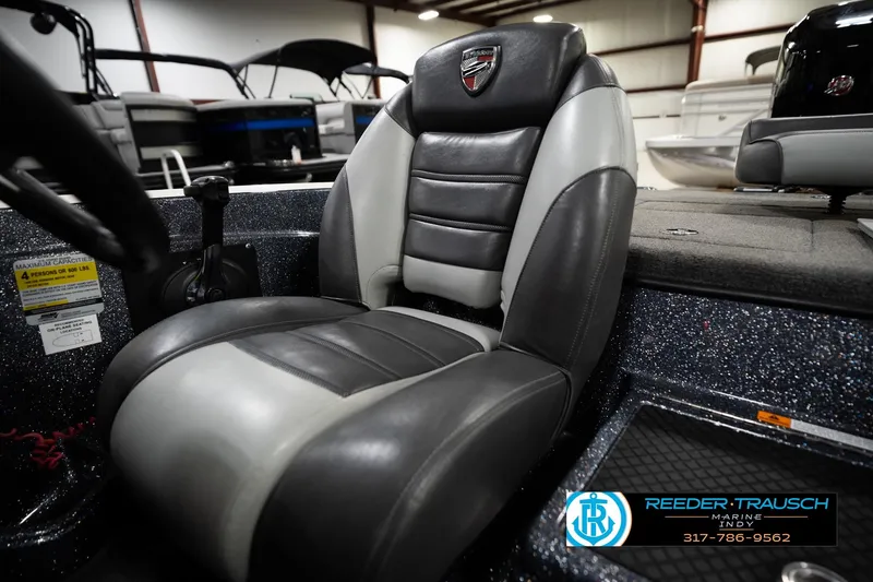 Slide: The Image of 2015 Triton 18TRX boat seat in showroom, featuring black and gray upholstery. - 38