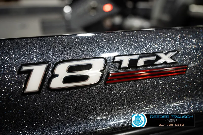 Slide: The Image of 2015 Triton 18TRX boat logo with metallic finish and dealership contact details. - 53