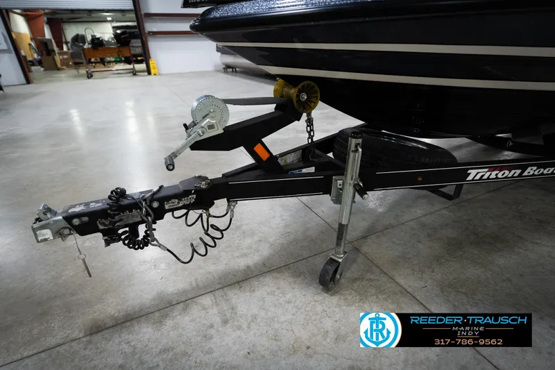 Slide: The Image of Trailer hitch of a 2015 Triton 18TRX boat in a garage setting. - 55