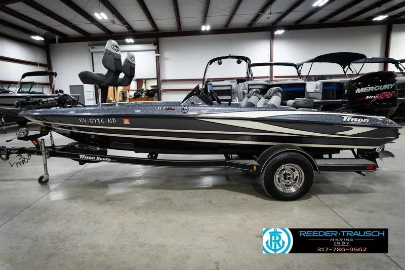 Slide: The Image of 2015 Triton 18TRX boat in showroom, featuring sleek design and trailer. - 9
