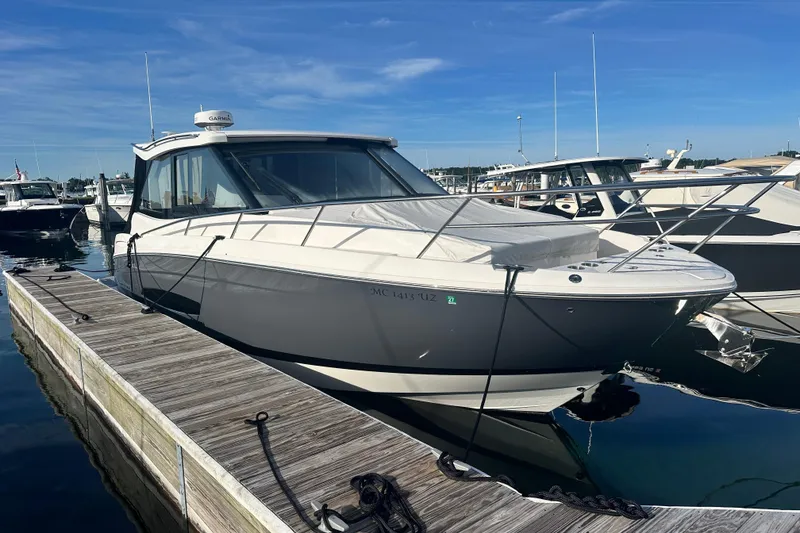 The Image of 2023 Regal 36 Grande Coupe docked at marina under clear blue sky. - 0