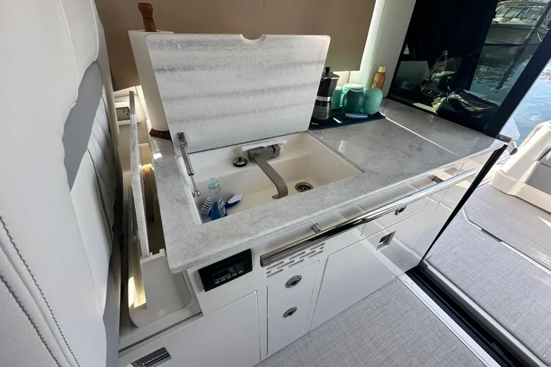 Slide: The Image of 2023 Regal 36 Grande Coupe yacht kitchenette with sink and countertop accessories. - 13
