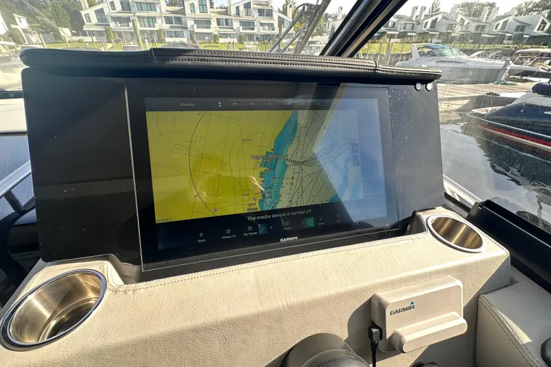 Slide: The Image of 2023 Regal 36 Grande Coupe cockpit with Garmin navigation display, marina view in background. - 15
