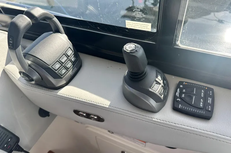 Slide: The Image of 2023 Regal 36 Grande Coupe boat controls, featuring joystick and throttle levers. - 16