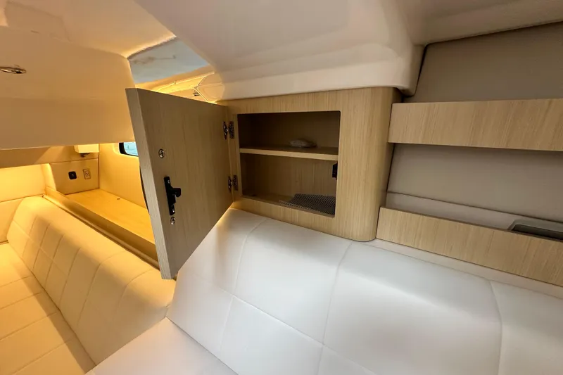 Slide: The Image of Interior of 2023 Regal 36 Grande Coupe with open wooden cabinet and white seating. - 23