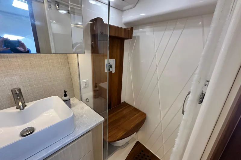 Slide: The Image of Luxurious bathroom in 2023 Regal 36 Grande Coupe yacht with modern fixtures and wooden accents. - 27