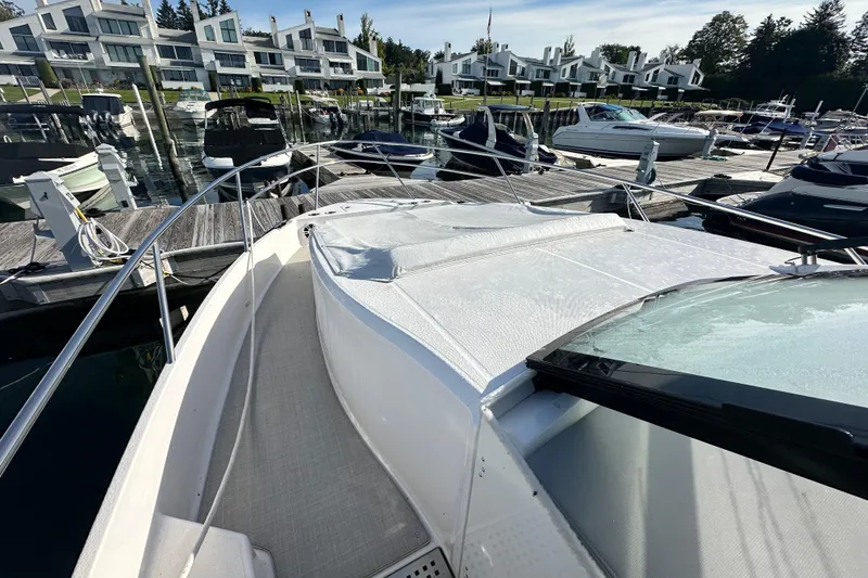 Slide: The Image of 2023 Regal 36 Grande Coupe docked at a marina with modern waterfront homes. - 36