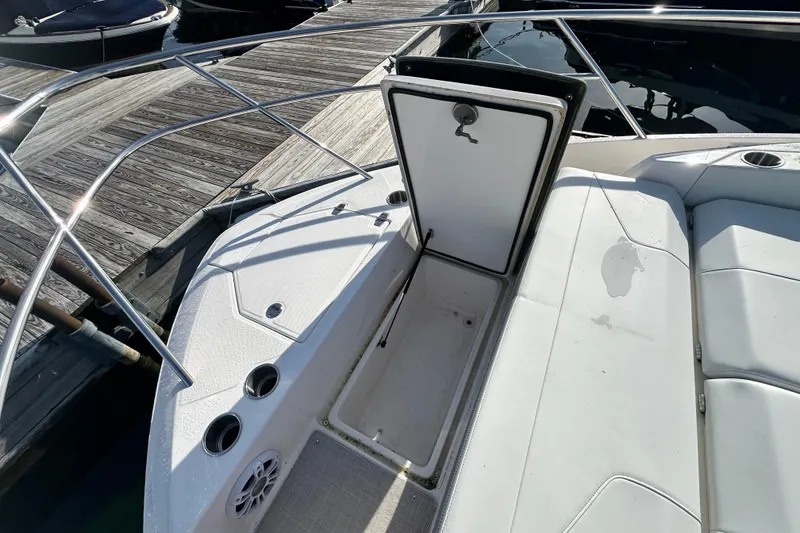 Slide: The Image of 2023 Regal 36 Grande Coupe boat deck with open storage compartment at dock. - 38