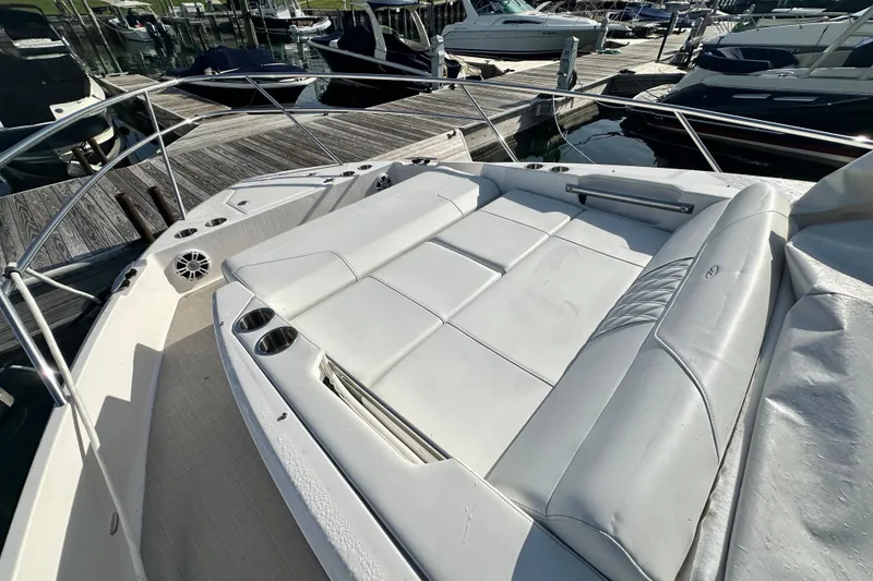 Slide: The Image of 2023 Regal 36 Grande Coupe boat with spacious white seating at a marina. - 39