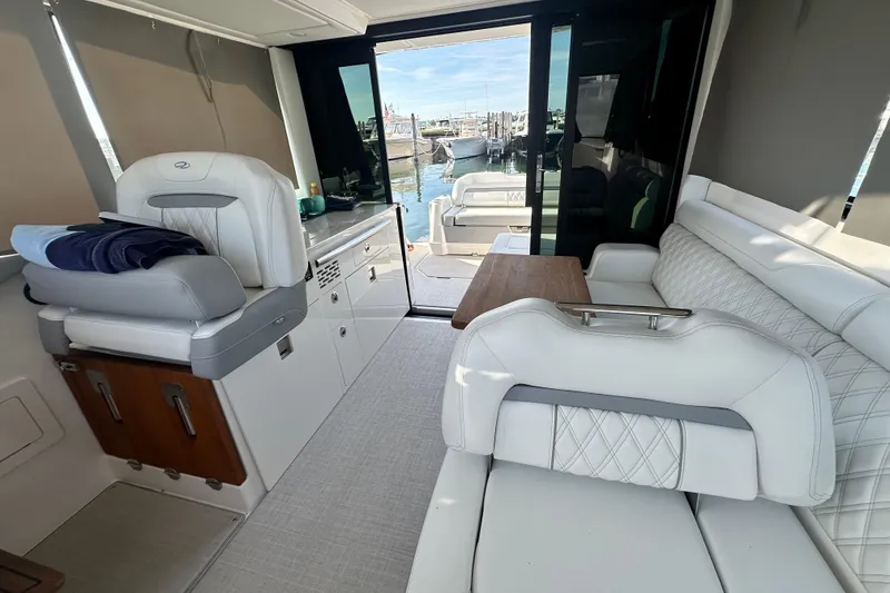 Slide: The Image of Luxurious interior of 2023 Regal 36 Grande Coupe yacht with white seating and wooden accents. - 42