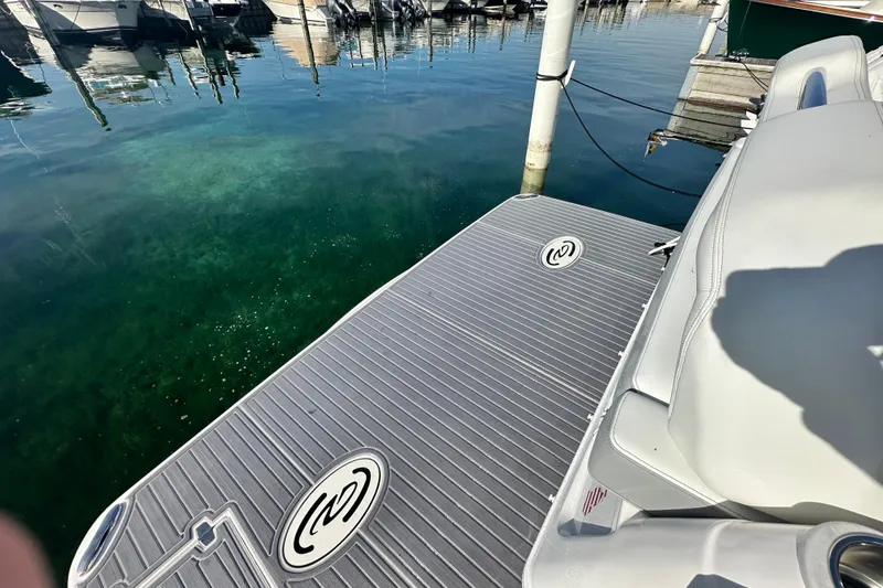 Slide: The Image of 2023 Regal 36 Grande Coupe swim platform at marina, clear water view. - 47