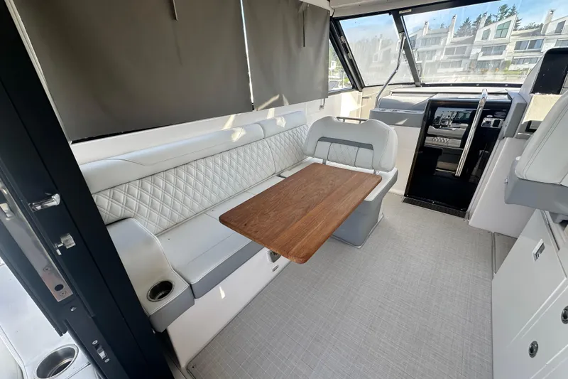 Slide: The Image of 2023 Regal 36 Grande Coupe interior with elegant seating and wooden table. - 8