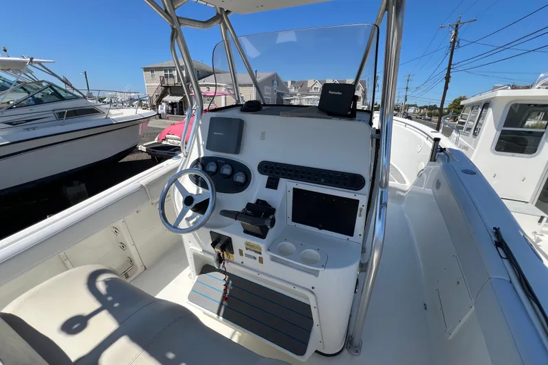 Slide: The Image of 2003 Triton 2690 CC boat cockpit with steering wheel and navigation equipment. - 11