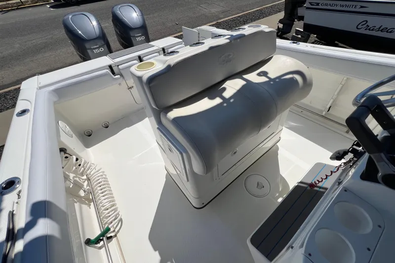 Slide: The Image of 2003 Triton 2690 CC boat interior with dual Yamaha 150 engines, white seating, and storage. - 12