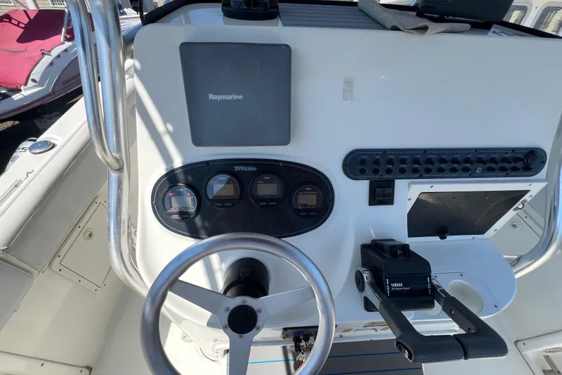 Slide: The Image of Control panel of a 2003 Triton 2690 CC boat with steering wheel and gauges. - 16