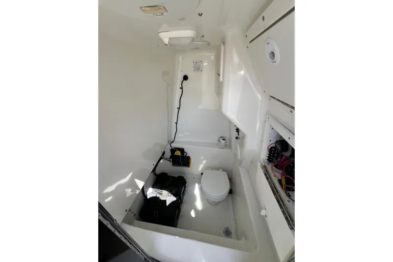 Slide: The Image of Interior of 2003 Triton 2690 CC boat featuring a compact marine toilet. - 17