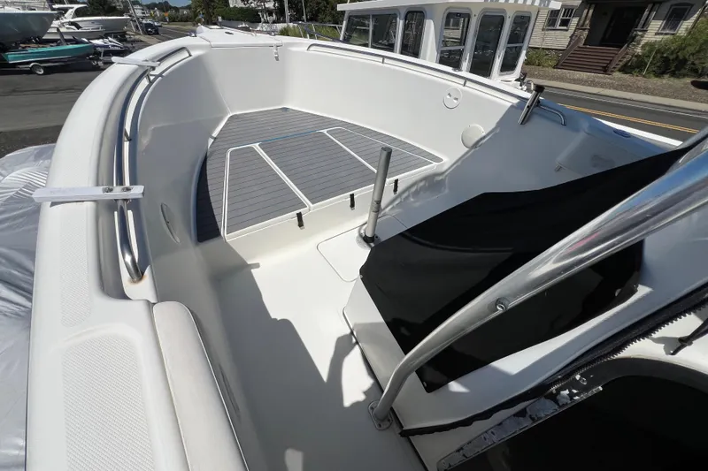 Slide: The Image of 2003 Triton 2690 CC boat interior with sleek white deck and stainless steel railings. - 20