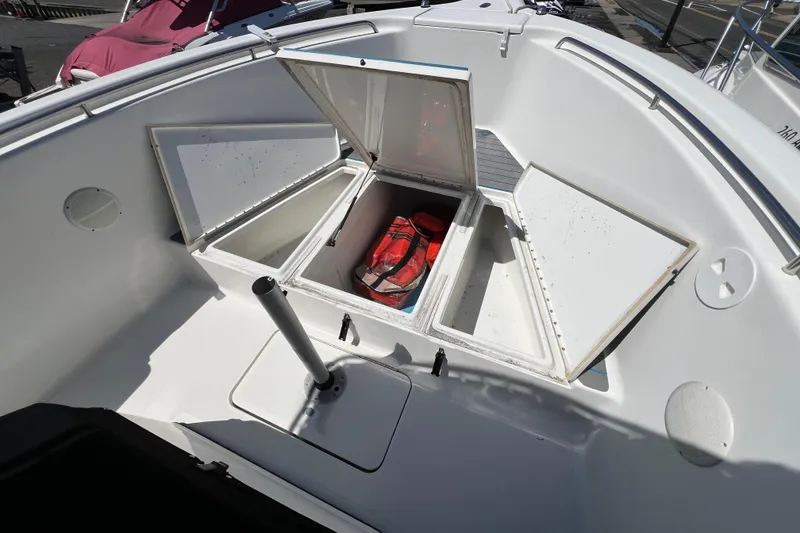 Slide: The Image of Open storage compartments on a 2003 Triton 2690 CC boat deck. - 22