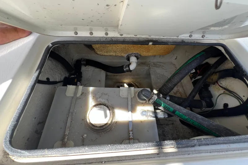Slide: The Image of 2003 Triton 2690 CC boat compartment with hoses and storage tank. - 25