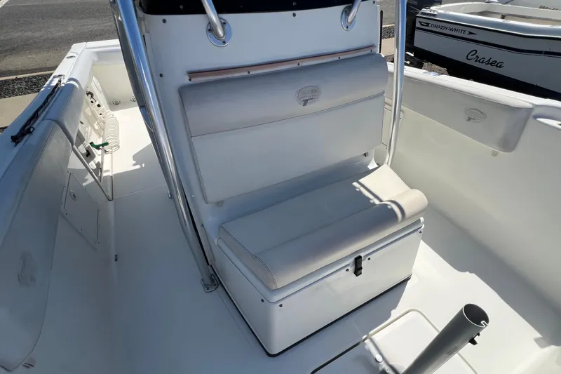 Slide: The Image of 2003 Triton 2690 CC boat interior with white seating and storage. - 26