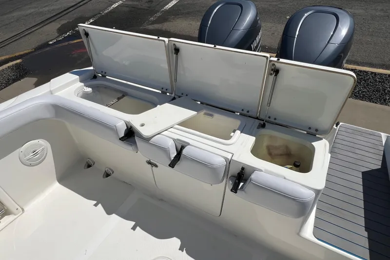 Slide: The Image of 2003 Triton 2690 CC boat with open storage compartments and dual Yamaha engines. - 27