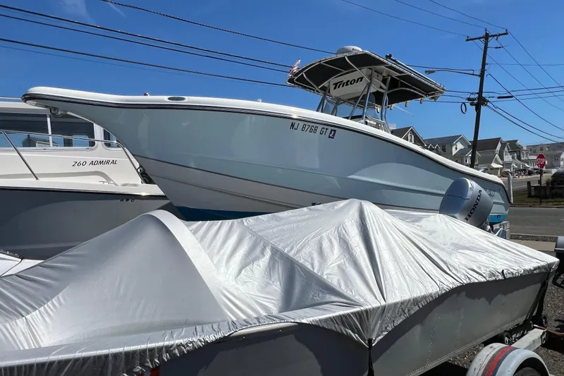 Slide: The Image of 2003 Triton 2690 CC boat on trailer, parked outdoors under clear blue sky. - 3