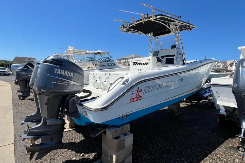 Slide: The Image of 2003 Triton 2690 CC boat with Yamaha engines, displayed for sale on blocks. - 6