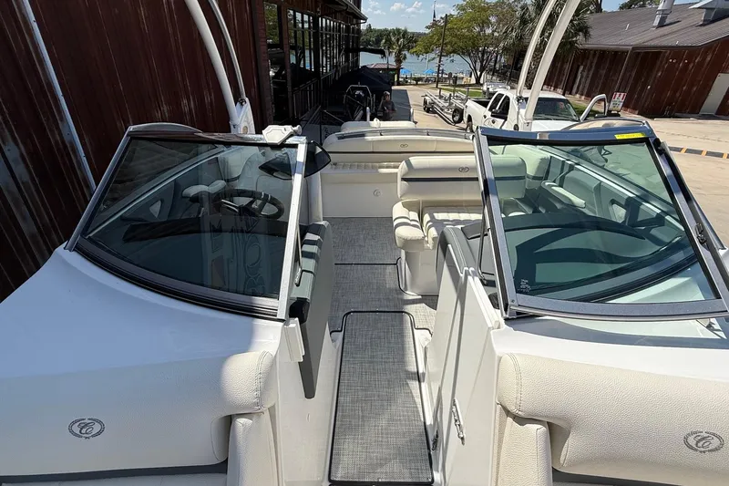 Slide: The Image of 2019 Cobalt R3 boat interior with seating and steering wheel, docked near a wooden building. - 13