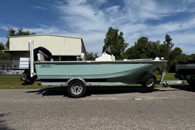Slide: The Image of 2022 Boston Whaler 170 Montauk boat on trailer, parked outdoors under clear sky. - 3