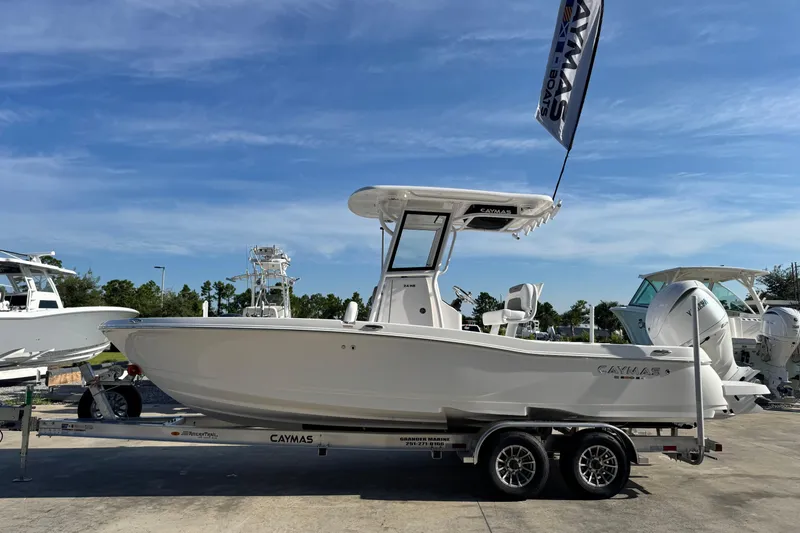 The Image of 2026 Caymas 24 HB boat on trailer under clear blue sky. - 1