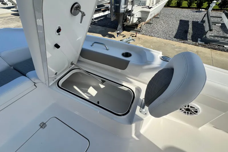 Slide: The Image of 2026 Caymas 24 HB boat interior with open storage compartment and cushioned seating. - 11