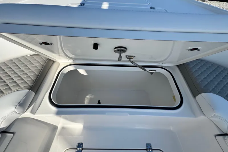 Slide: The Image of Open storage compartment on 2026 Caymas 24 HB boat with quilted seating. - 12