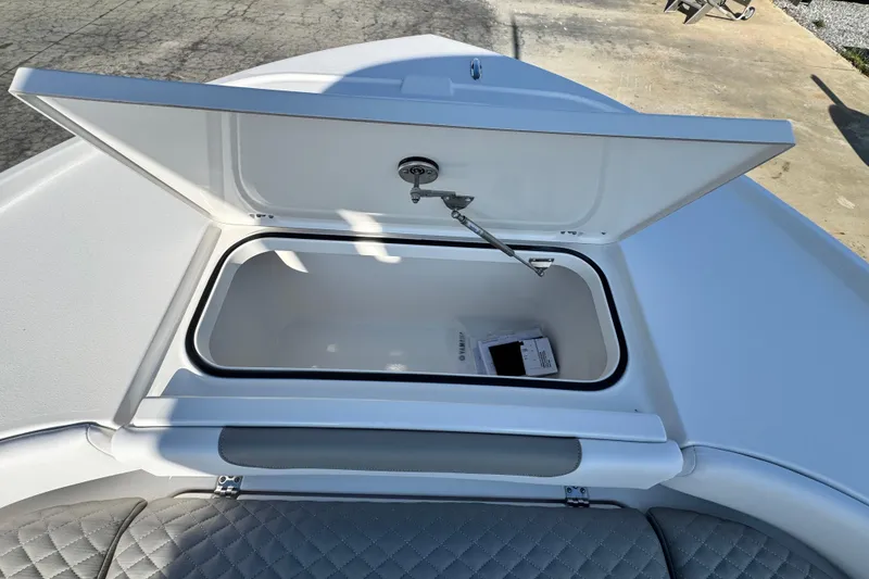 Slide: The Image of Open storage compartment on 2026 Caymas 24 HB boat, featuring quilted seating. - 13