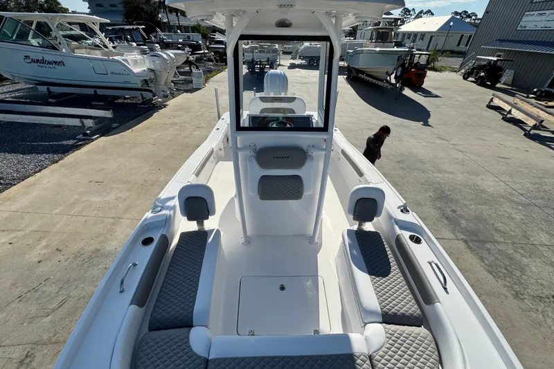 Slide: The Image of 2026 Caymas 24 HB boat with spacious seating and modern design at a marina. - 14